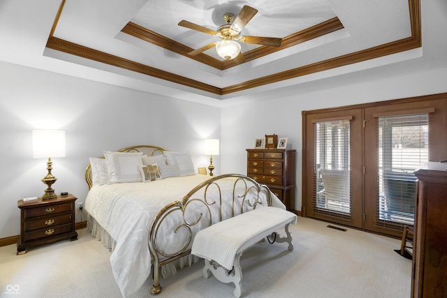 bedroom with a tray ceiling, access to outside, and light colored carpet