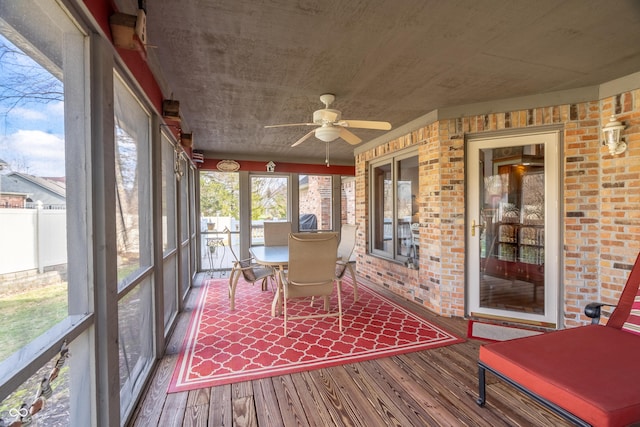 unfurnished sunroom with ceiling fan