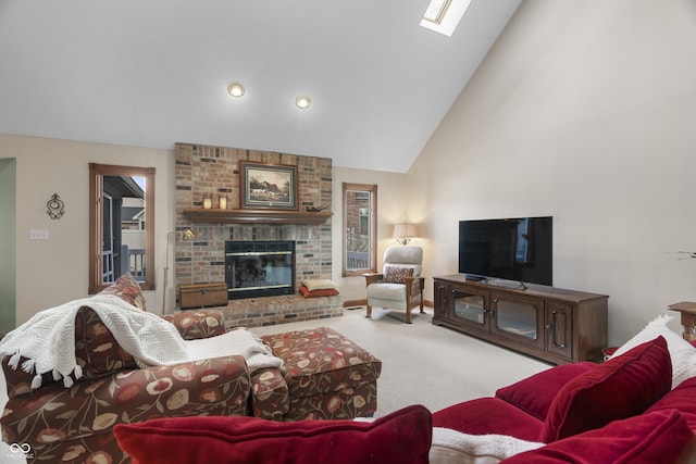 carpeted living room with a brick fireplace, a skylight, and high vaulted ceiling