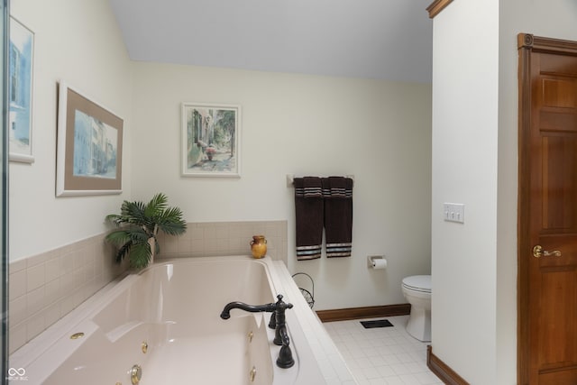 bathroom with tiled bath, tile patterned floors, and toilet