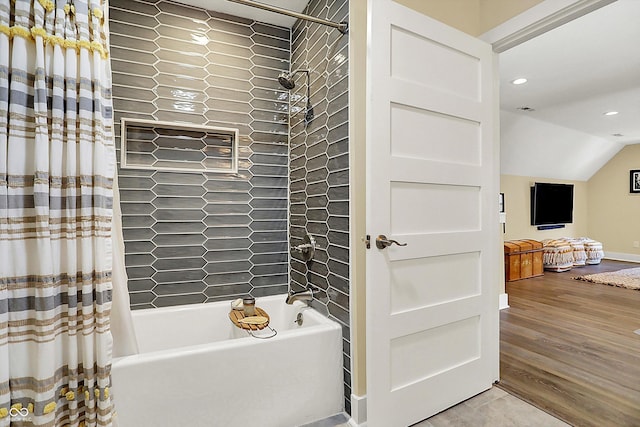 bathroom featuring hardwood / wood-style flooring, vaulted ceiling, and shower / bath combo with shower curtain