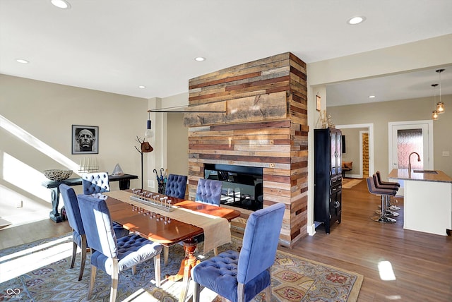 dining area featuring sink, dark wood-type flooring, and a multi sided fireplace