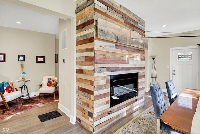 office space with hardwood / wood-style floors and a multi sided fireplace