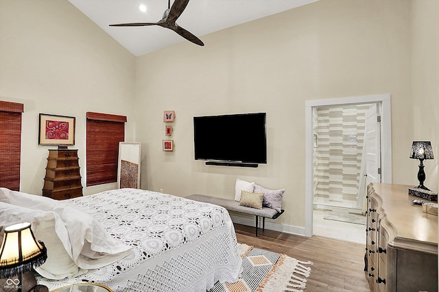 bedroom with ensuite bathroom, high vaulted ceiling, ceiling fan, and light hardwood / wood-style flooring