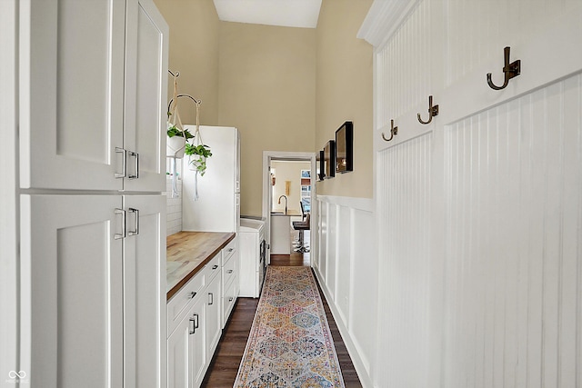 interior space with dark wood-type flooring, independent washer and dryer, and a towering ceiling