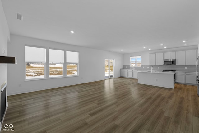 unfurnished living room featuring dark hardwood / wood-style flooring and sink