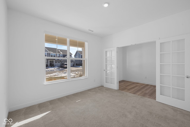 carpeted spare room with french doors