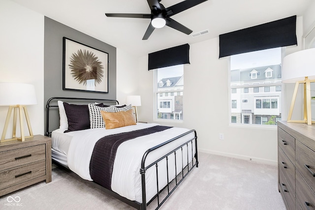 bedroom featuring multiple windows, light carpet, and ceiling fan