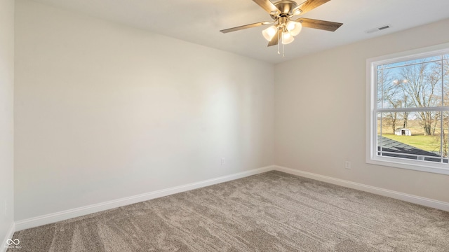 carpeted spare room featuring ceiling fan