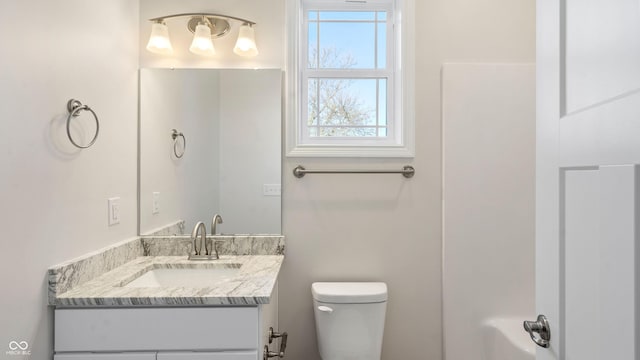 bathroom with vanity, a wealth of natural light, and toilet