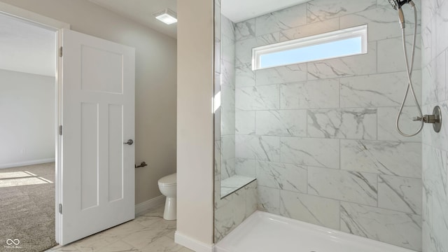 bathroom with tiled shower and toilet