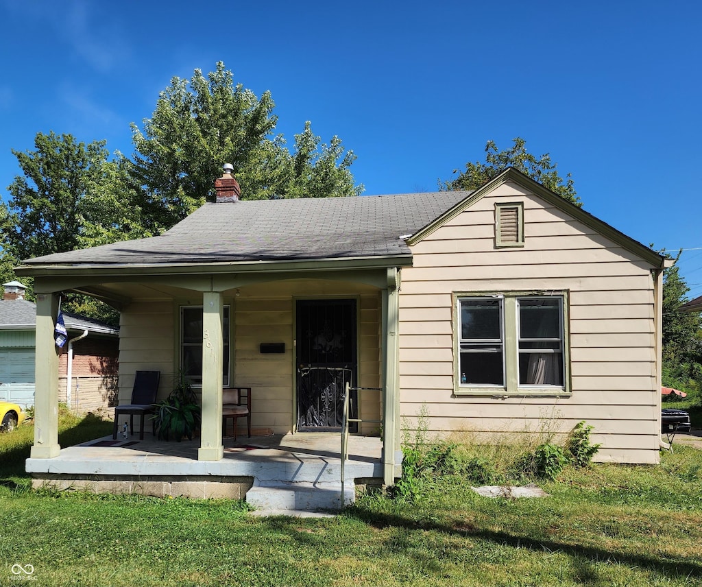 back of house with a porch and a lawn