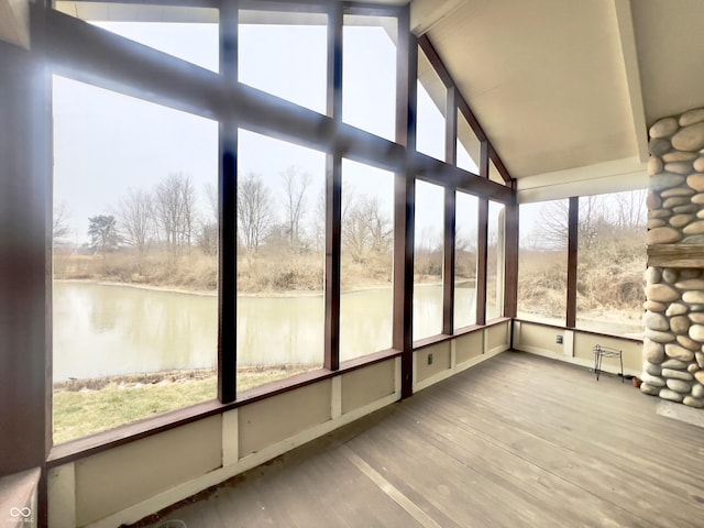 unfurnished sunroom featuring lofted ceiling with beams and a water view