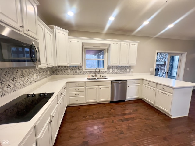 kitchen with white cabinetry, stainless steel appliances, kitchen peninsula, and sink