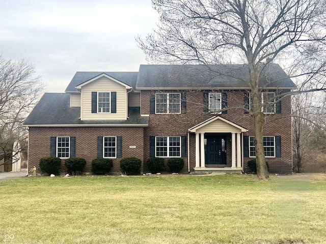 colonial-style house featuring a front lawn