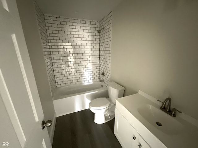 full bathroom featuring tiled shower / bath, wood-type flooring, vanity, and toilet