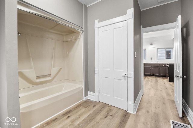 bathroom featuring vanity, wood-type flooring, and  shower combination