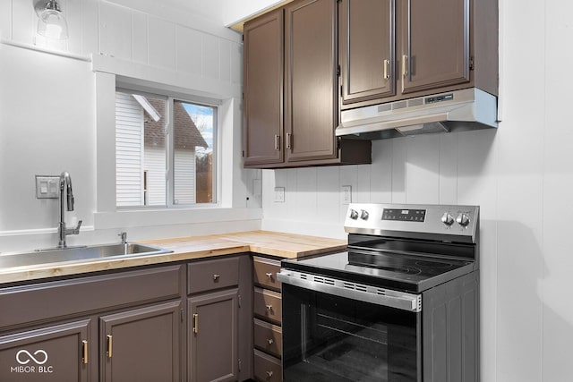 kitchen featuring electric stove, sink, dark brown cabinets, and butcher block countertops