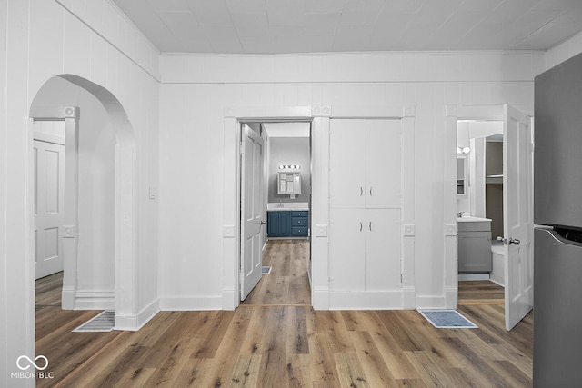 interior space featuring sink, crown molding, and wood-type flooring