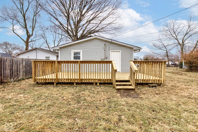 back of house featuring a wooden deck and a lawn