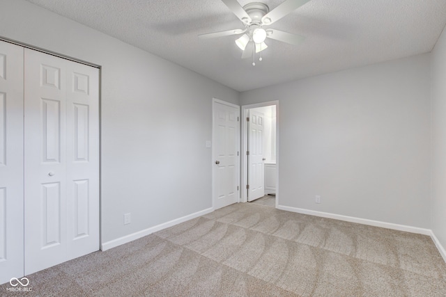 spare room featuring ceiling fan, light colored carpet, and a textured ceiling