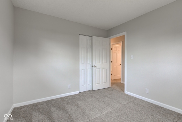 unfurnished bedroom with a closet and light carpet