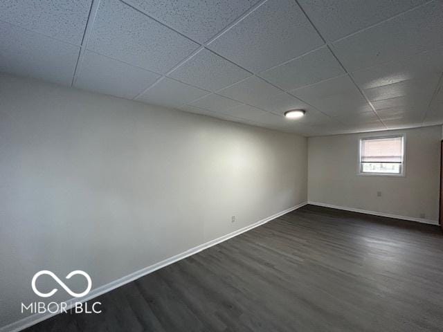 basement featuring dark hardwood / wood-style floors and a drop ceiling