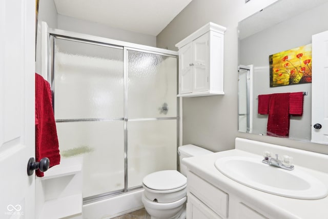 full bathroom with vanity, a shower stall, and toilet