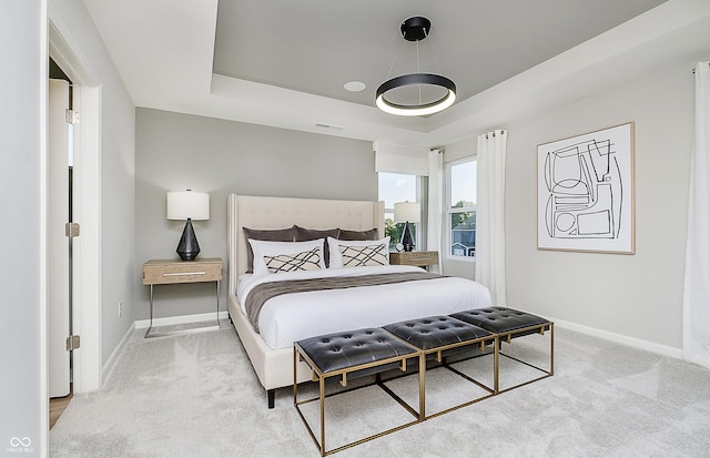 carpeted bedroom with a tray ceiling