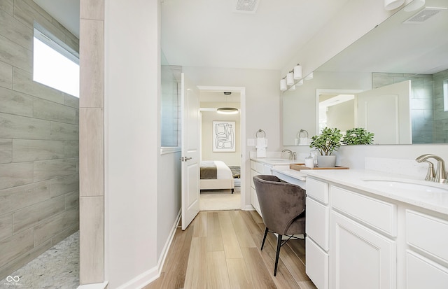 bathroom with vanity, hardwood / wood-style floors, and a tile shower