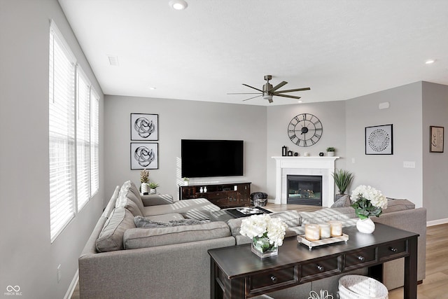 living room with hardwood / wood-style flooring, a wealth of natural light, and ceiling fan