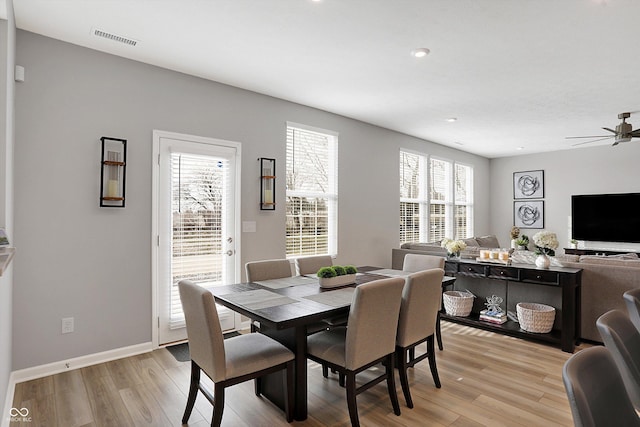 dining space with ceiling fan and light hardwood / wood-style flooring