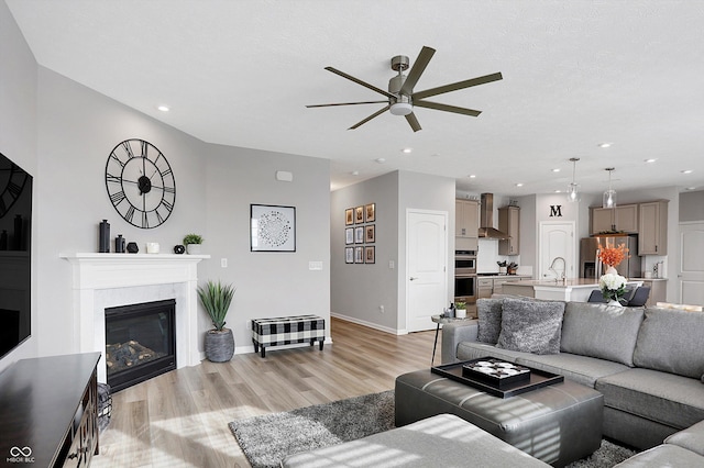 living room featuring ceiling fan and light hardwood / wood-style flooring