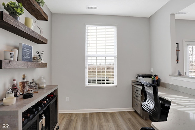 office space featuring plenty of natural light and light hardwood / wood-style floors