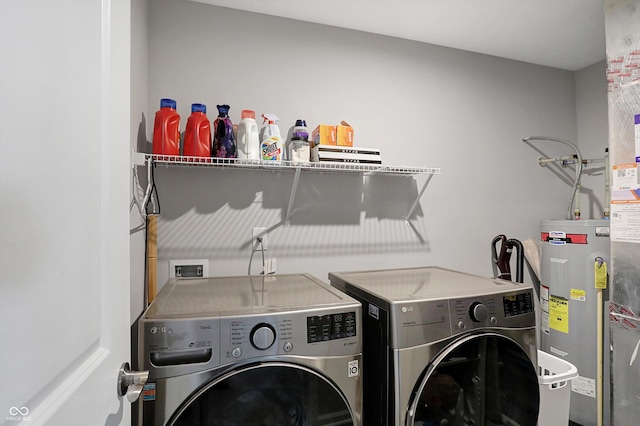 laundry room with water heater and washer and dryer