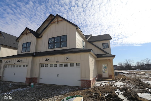 view of front of home featuring driveway, brick siding, board and batten siding, and an attached garage