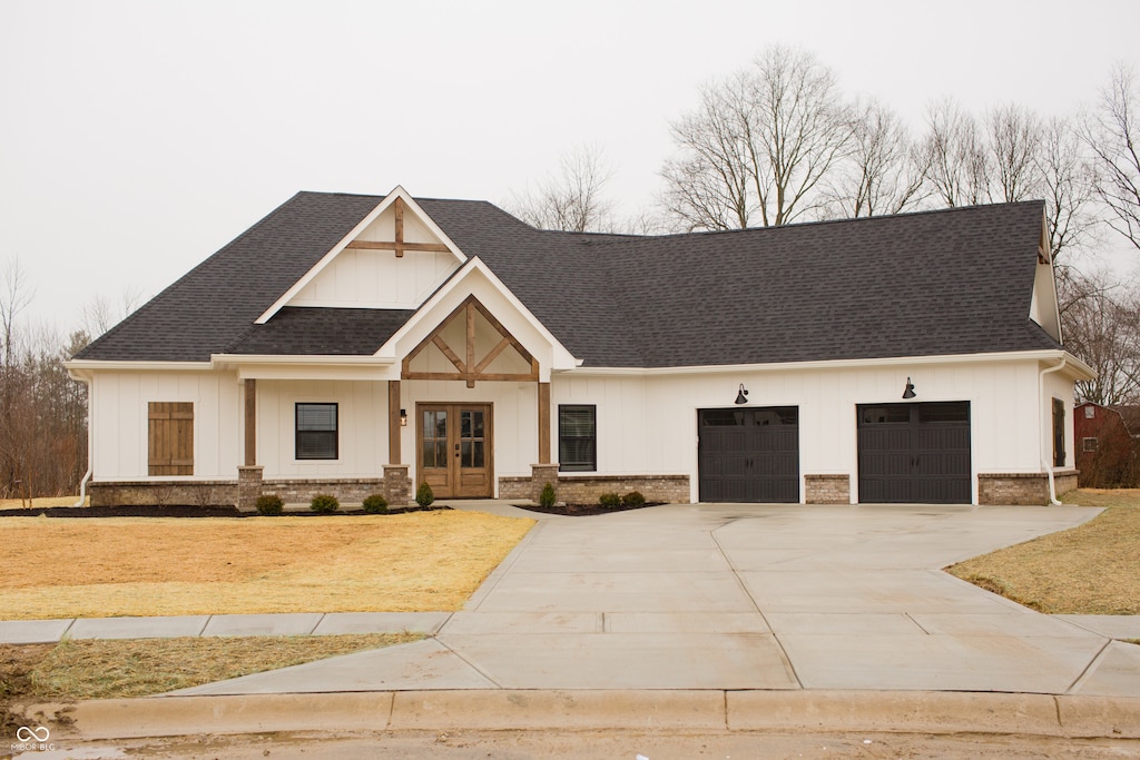 view of front facade featuring a garage, a front lawn, and french doors