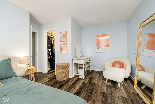 bedroom with dark hardwood / wood-style flooring, a spacious closet, and a closet