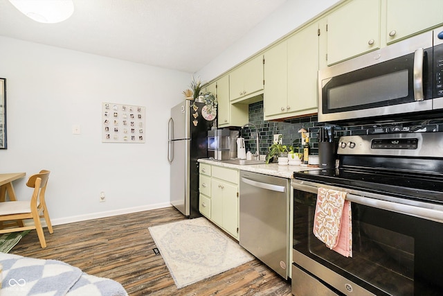 kitchen featuring dark hardwood / wood-style flooring, sink, backsplash, and stainless steel appliances