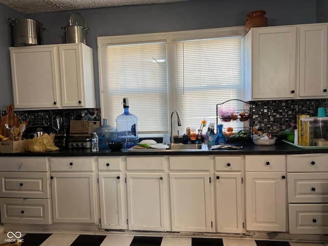 kitchen with white cabinetry, sink, and decorative backsplash