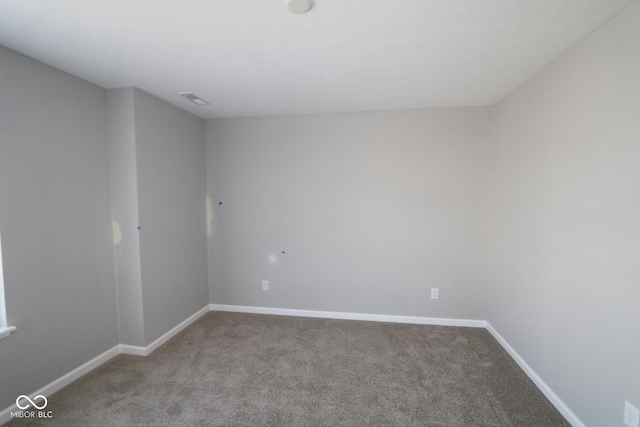 carpeted spare room featuring visible vents and baseboards