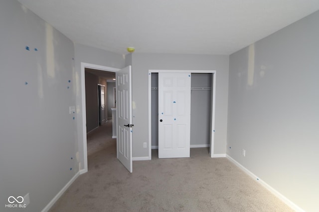 unfurnished bedroom featuring a closet, carpet flooring, and baseboards