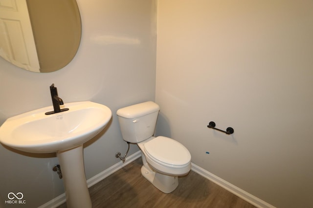 bathroom featuring baseboards, toilet, and wood finished floors