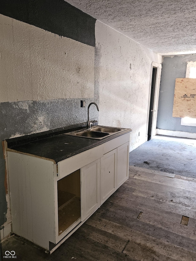 kitchen with dark hardwood / wood-style flooring, sink, and white cabinets