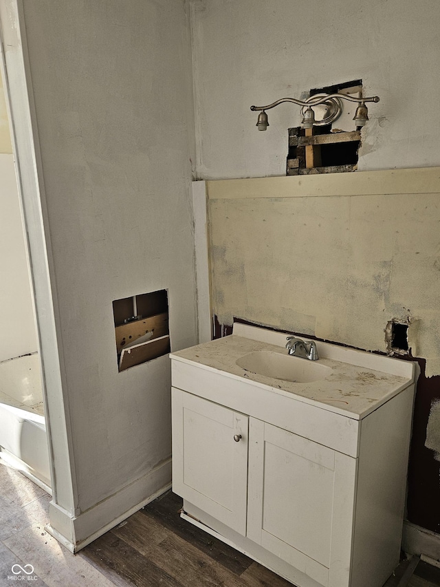 bathroom with vanity, hardwood / wood-style flooring, and a tub