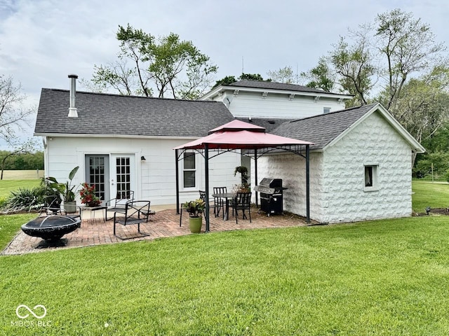 12801 E Edgewater Rd, Albany, IN 47320 - rear view of property featuring an outdoor fire pit, roof with shingles, a gazebo, a lawn, and a patio