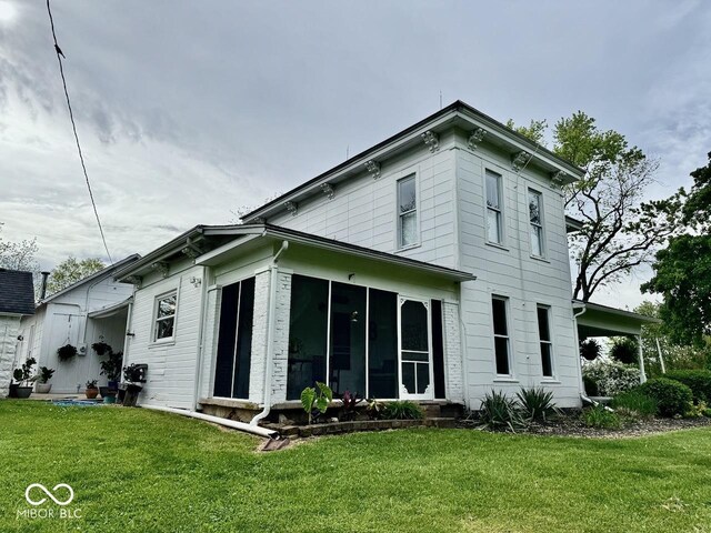 12801 E Edgewater Rd, Albany, IN 47320 - back of property featuring a sunroom and a lawn