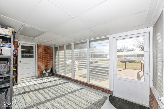 sunroom with a drop ceiling and a healthy amount of sunlight