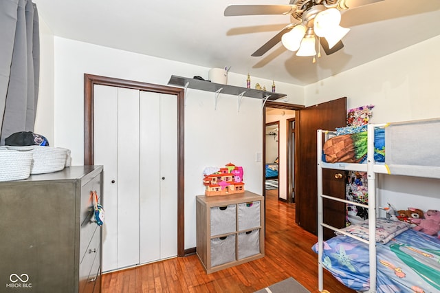 bedroom with wood-type flooring, ceiling fan, and a closet