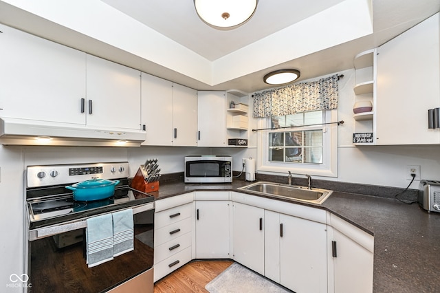 kitchen featuring white cabinetry, sink, light hardwood / wood-style flooring, and appliances with stainless steel finishes